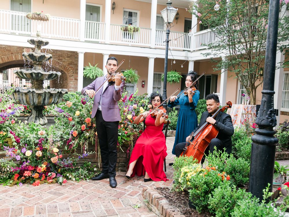 The ALPEZ string quartet performing in a flower-filled courtyard
